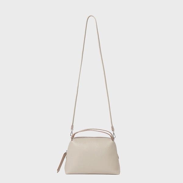 Ang GIANNI CHIARINI ALIFA crossbody bag na gawa sa Italian beige leather ay nagtatampok ng minimalist na disenyo, adjustable straps, maikling hawakan, at zippered top.